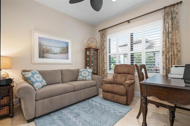 living room with a ceiling fan, baseboards, and light tile patterned floors