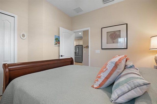 bedroom with visible vents and stainless steel refrigerator with ice dispenser