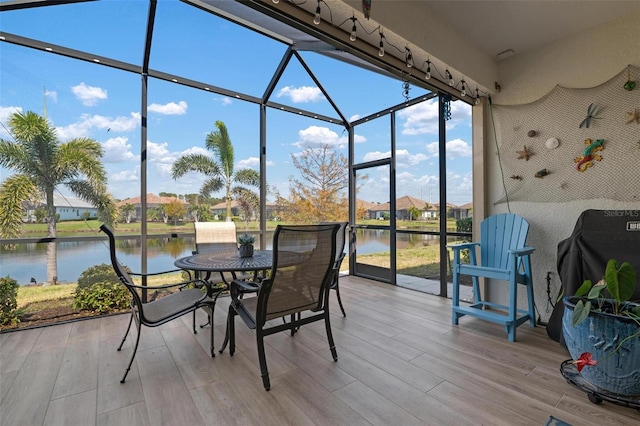 sunroom featuring a water view