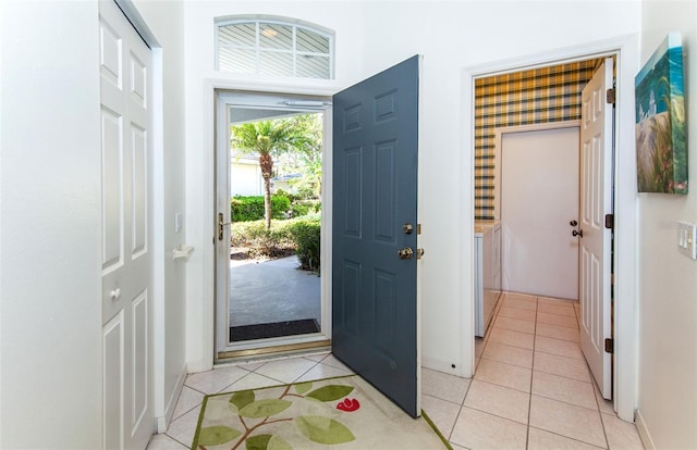 entrance foyer featuring washing machine and dryer and light tile patterned floors