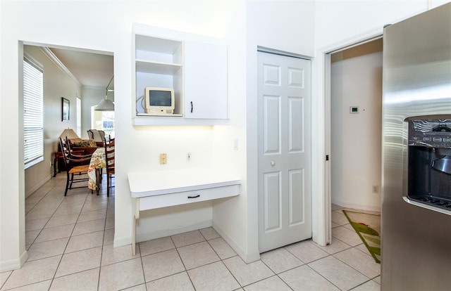 hallway featuring light tile patterned floors, baseboards, and crown molding