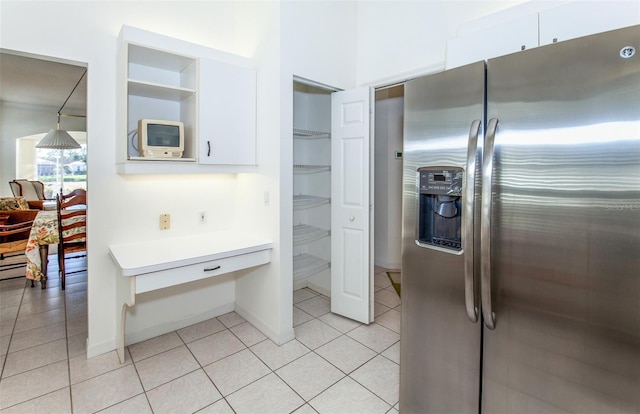 kitchen with light tile patterned flooring, white cabinetry, light countertops, and stainless steel fridge with ice dispenser