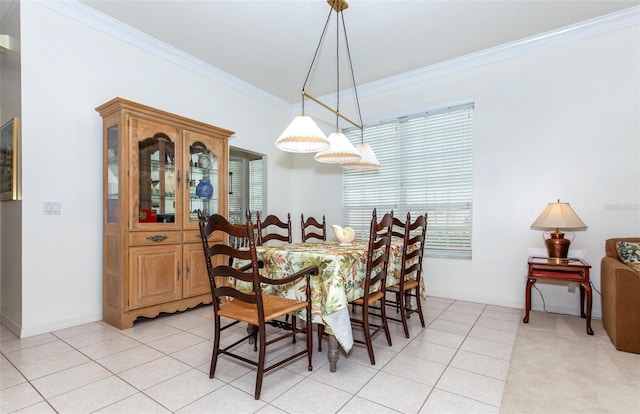 dining space with ornamental molding, light tile patterned flooring, and baseboards