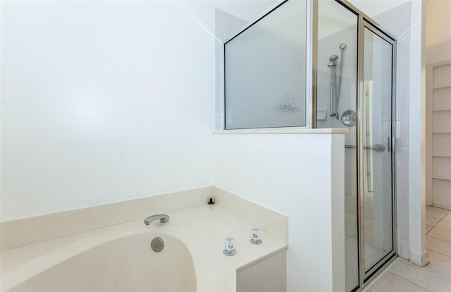 full bathroom with a garden tub, a shower stall, and tile patterned floors