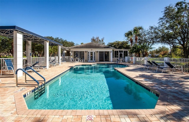 community pool featuring a patio and fence