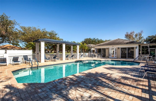 community pool with a patio, french doors, and fence