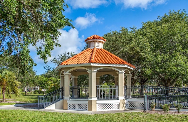 view of home's community with fence, a gazebo, and a lawn