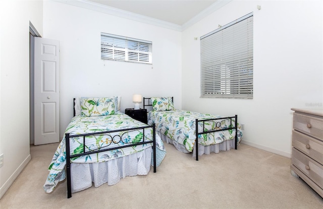 carpeted bedroom with ornamental molding and baseboards