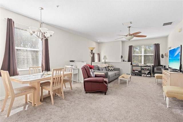 living room featuring visible vents, light carpet, and ceiling fan with notable chandelier