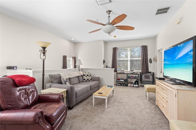 carpeted living area featuring visible vents and a ceiling fan