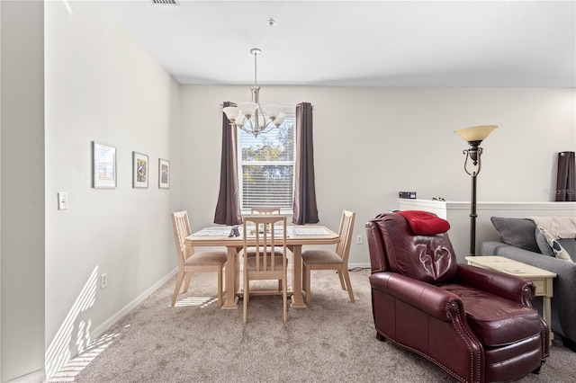 carpeted dining space with visible vents, baseboards, and a notable chandelier