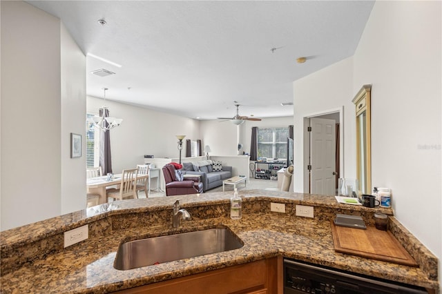 kitchen featuring dishwasher, dark stone countertops, visible vents, and a sink