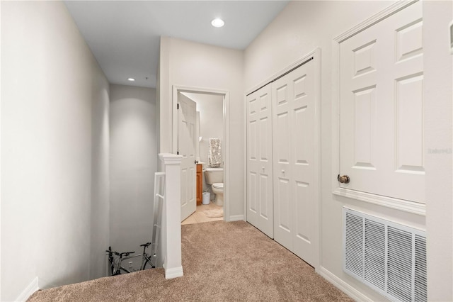 corridor featuring carpet floors, recessed lighting, visible vents, and baseboards