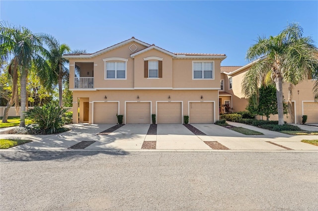 townhome / multi-family property with driveway, an attached garage, and stucco siding