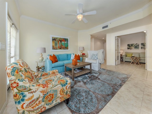 tiled living area with visible vents, ornamental molding, ceiling fan, and baseboards