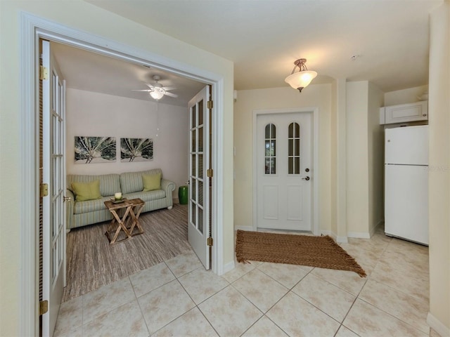 entryway featuring french doors, baseboards, and light tile patterned floors