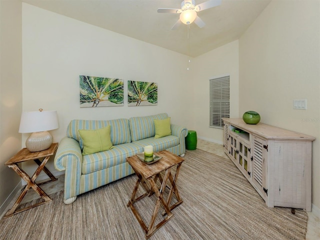 living room with ceiling fan, baseboards, and light colored carpet