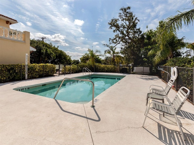 community pool with a patio and fence