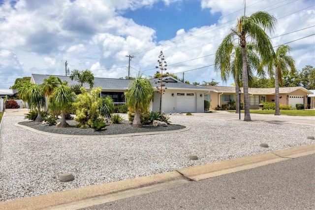 single story home featuring a garage, driveway, and stucco siding