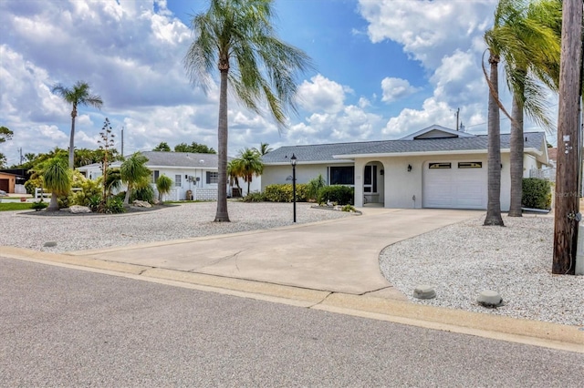 ranch-style house featuring a garage, concrete driveway, and stucco siding