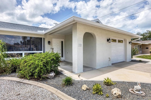 view of front facade featuring driveway, an attached garage, and stucco siding