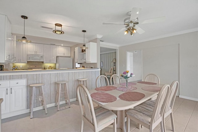dining area with light tile patterned flooring, crown molding, baseboards, and ceiling fan