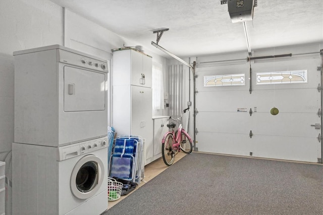 garage featuring a garage door opener and stacked washer / drying machine