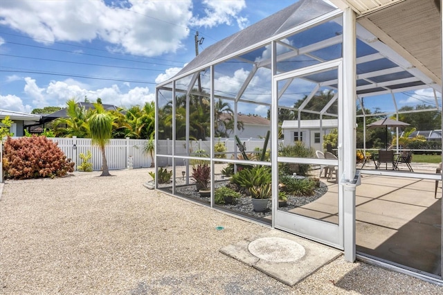 exterior space featuring glass enclosure, fence, and a patio