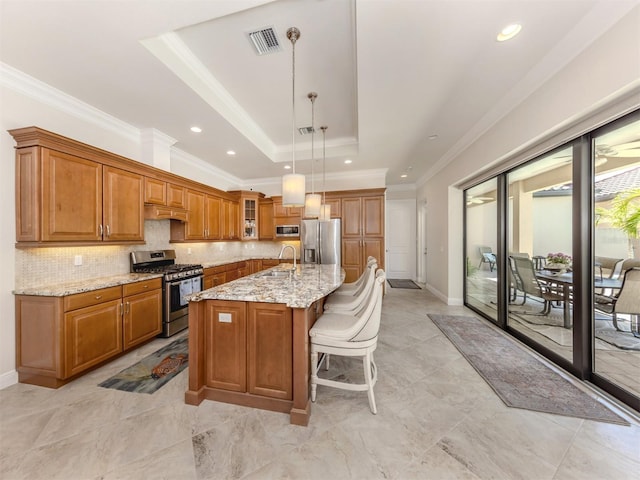 kitchen featuring visible vents, brown cabinets, a sink, stainless steel appliances, and a raised ceiling