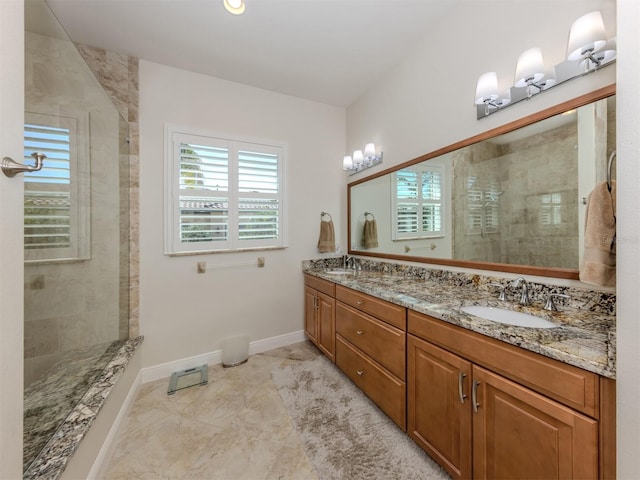 bathroom featuring double vanity, baseboards, a tile shower, and a sink