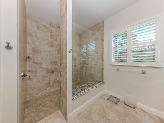 bathroom featuring baseboards and a tile shower