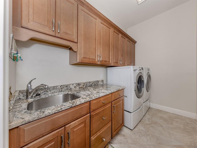 laundry room with washer and dryer, cabinet space, baseboards, and a sink