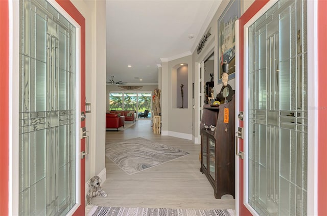 entryway featuring crown molding, baseboards, and wood finished floors