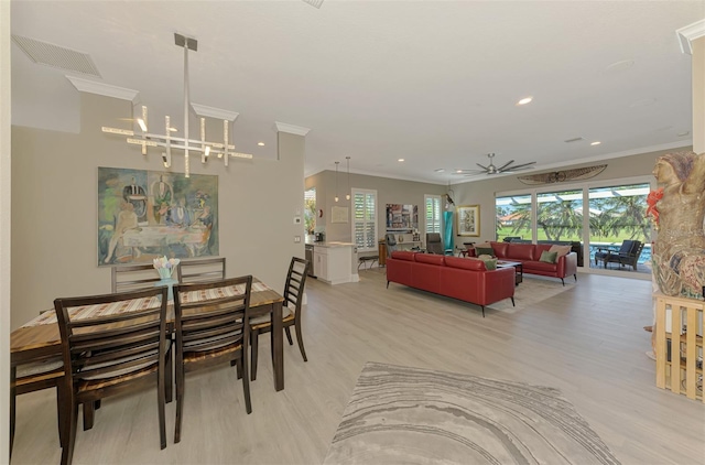 dining space with light wood-style flooring, recessed lighting, ceiling fan with notable chandelier, visible vents, and ornamental molding