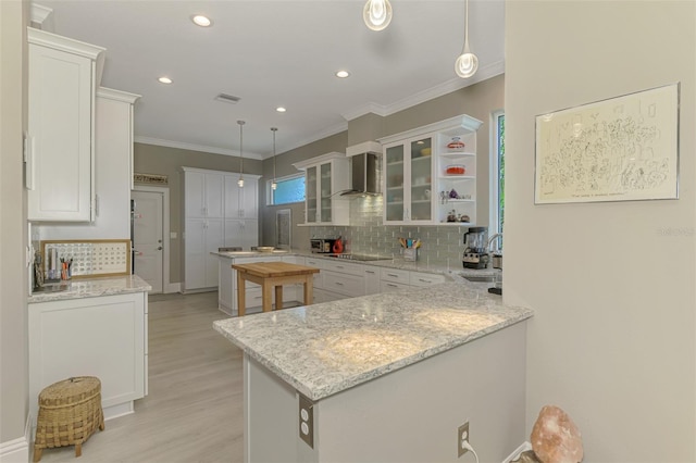 kitchen with decorative backsplash, white cabinetry, wall chimney exhaust hood, and black electric cooktop