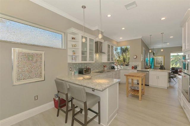 kitchen with dishwasher, glass insert cabinets, a peninsula, black electric cooktop, and wall chimney range hood