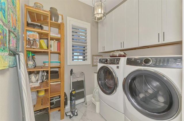 clothes washing area featuring marble finish floor, baseboards, cabinet space, and washing machine and clothes dryer