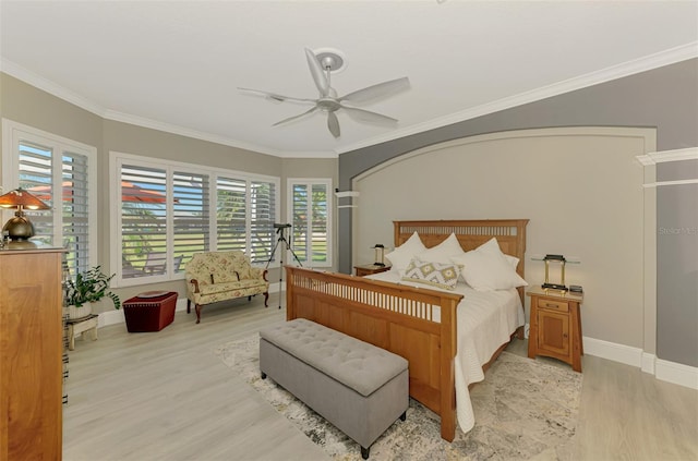 bedroom featuring a ceiling fan, crown molding, light wood-style flooring, and baseboards