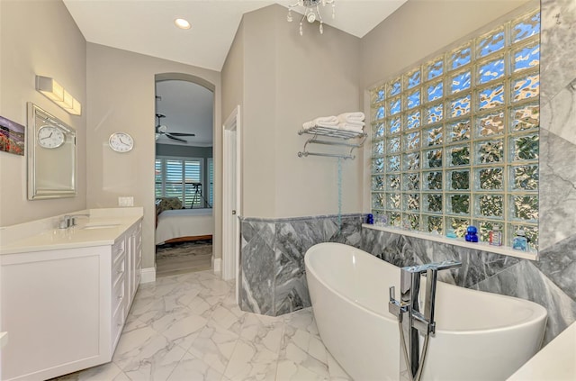 ensuite bathroom featuring marble finish floor, recessed lighting, ensuite bathroom, a ceiling fan, and a freestanding tub