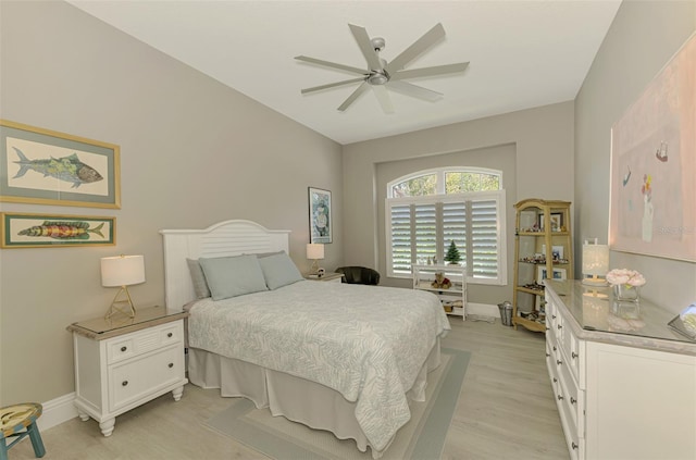 bedroom with baseboards, ceiling fan, and light wood-style floors