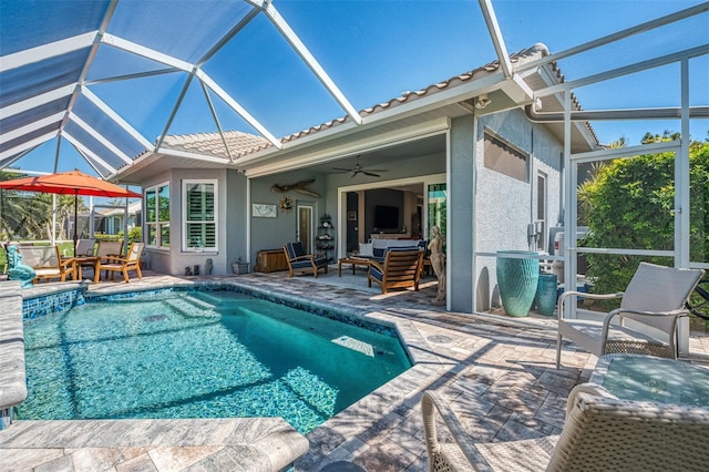 pool with a patio area, ceiling fan, and glass enclosure