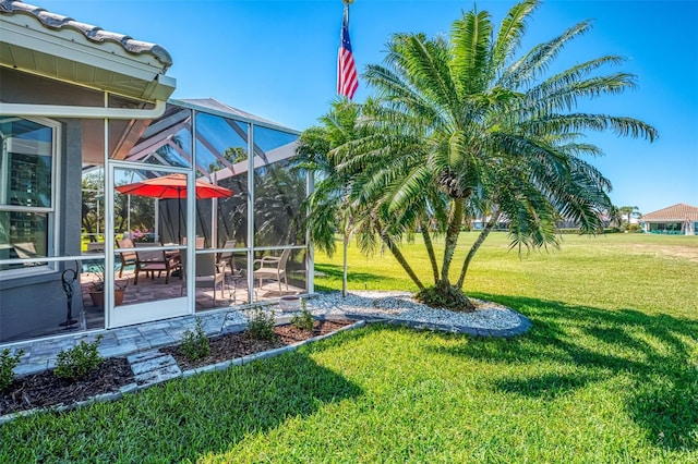 view of yard featuring glass enclosure and a patio area