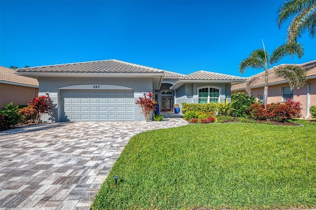 ranch-style home with an attached garage, a front lawn, and stucco siding