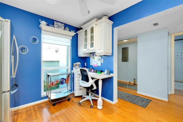 office space with light wood finished floors, visible vents, ceiling fan, and baseboards