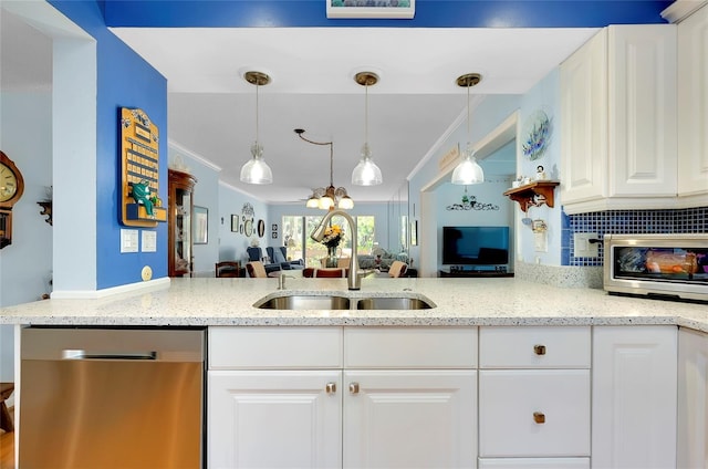 kitchen with a sink, stainless steel appliances, light stone counters, and ornamental molding