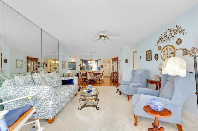 carpeted living room with crown molding and ceiling fan with notable chandelier