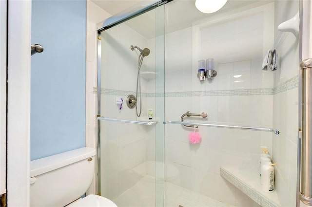 bathroom featuring a shower stall and toilet