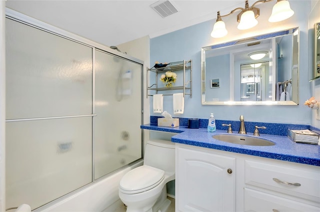 bathroom featuring visible vents, vanity, toilet, and shower / bath combination with glass door