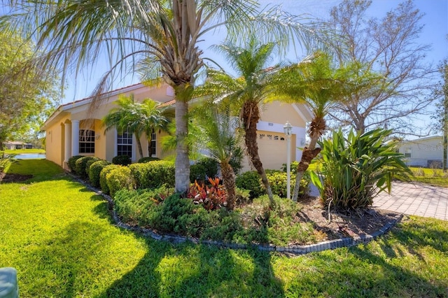 view of home's exterior featuring a garage, a yard, and stucco siding