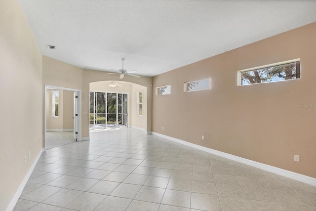 spare room with baseboards, visible vents, a ceiling fan, and light tile patterned flooring